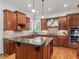 Gourmet kitchen boasts an island, stainless appliances, granite countertops, and custom cabinetry at 642 Bear Tree Creek, Chapel Hill, NC 27517