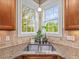 Kitchen corner with granite countertops, tiled backsplash, stainless sink, and natural light from bright windows at 642 Bear Tree Creek, Chapel Hill, NC 27517