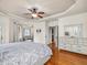 Bright main bedroom with hardwood floors, tray ceiling, and a doorway leading to a bathroom at 642 Bear Tree Creek, Chapel Hill, NC 27517
