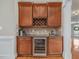 A well-appointed wet bar with custom cabinetry, wine storage, granite countertops, and a beverage refrigerator at 642 Bear Tree Creek, Chapel Hill, NC 27517