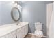 Clean bathroom featuring blue walls, white cabinets, and a well-lit mirror above the sink at 707 Cross Timbers Dr, Durham, NC 27713