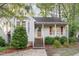 Inviting home exterior with a covered porch, red shutters, brick stairs, and lush landscaping at 707 Cross Timbers Dr, Durham, NC 27713
