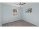 Carpeted bedroom with neutral walls featuring a ceiling fan and natural light at 7715 Bernadette Ln, Raleigh, NC 27615