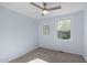 This cozy bedroom features soft blue walls, plush carpet, and a modern ceiling fan with overhead lighting at 7715 Bernadette Ln, Raleigh, NC 27615