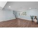 Cozy living room featuring wood floors, backyard access, staircase, and neutral walls at 7715 Bernadette Ln, Raleigh, NC 27615