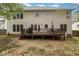 Home's backyard features a large deck, a well-kept yard, and a patio seating area at 8 Queensland Ct, Durham, NC 27712