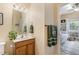 Cozy bathroom features a wood vanity with framed mirror and access to a bedroom at 8 Queensland Ct, Durham, NC 27712