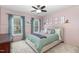 Cozy bedroom features soft pink walls, a ceiling fan, and natural light from the two windows at 8 Queensland Ct, Durham, NC 27712