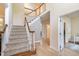 Bright foyer featuring hardwood floors, staircase with white balusters, and a view into other rooms at 8 Queensland Ct, Durham, NC 27712