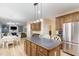 Island kitchen with oak cabinets and an open floorplan to living space at 8 Queensland Ct, Durham, NC 27712