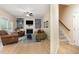 Spacious living room with fireplace, built-in shelving, and hardwood floors leads to carpeted stairs at 8 Queensland Ct, Durham, NC 27712