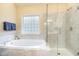 Elegant main bathroom with a glass shower, large soaking tub and marble countertops at 8 Queensland Ct, Durham, NC 27712