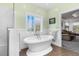 Bright bathroom featuring a standalone tub with window and white wainscoting at 9026 Privette Hill Ln, Spring Hope, NC 27882
