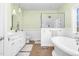 Bright bathroom features a soaking tub, tiled shower, and marble countertops at 9026 Privette Hill Ln, Spring Hope, NC 27882