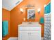 Well-lit bathroom featuring an orange accent wall and a marble vanity at 9026 Privette Hill Ln, Spring Hope, NC 27882