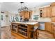 Well-lit kitchen features custom wood cabinets, large island with bookshelves, and stainless steel appliances at 9026 Privette Hill Ln, Spring Hope, NC 27882