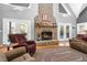 Living room with stone fireplace, hardwood floors, and plenty of natural light through french doors at 9026 Privette Hill Ln, Spring Hope, NC 27882