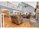 Open-concept living area featuring a stone fireplace, hardwood floors, and access to the kitchen and dining areas at 9026 Privette Hill Ln, Spring Hope, NC 27882