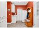 Mud room with storage, utility sink, coat rack, and red accent wall at 9026 Privette Hill Ln, Spring Hope, NC 27882