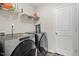 Laundry room featuring modern washer and dryer units with storage shelving at 95 Little Leaf Lane Ln, Clayton, NC 27527