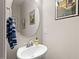 Small powder room with a pedestal sink, round mirror and decorative wall prints at 95 Little Leaf Lane Ln, Clayton, NC 27527