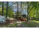 Backyard with stone path and mature trees leading to screened porch at 955 Sagamore Dr, Louisburg, NC 27549