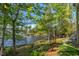 Scenic backyard view with mature trees, leading to a tranquil lake at 955 Sagamore Dr, Louisburg, NC 27549