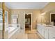 Bathroom features a soaking tub, shower, vanity, and doorway through to the bedroom at 955 Sagamore Dr, Louisburg, NC 27549