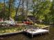 Picturesque waterfront property with a private dock and seating area, set against a backdrop of colorful landscaping and mature trees at 955 Sagamore Dr, Louisburg, NC 27549