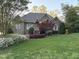 Charming brick home with a landscaped front yard, mature trees and flowering bushes at 955 Sagamore Dr, Louisburg, NC 27549