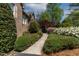 Well-manicured front yard with colorful azaleas lining a concrete walkway to a brick home at 955 Sagamore Dr, Louisburg, NC 27549