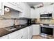 Close-up of kitchen featuring granite countertops, stainless steel appliances, and white cabinets at 955 Sagamore Dr, Louisburg, NC 27549