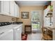 Bright laundry room featuring white cabinets, countertop, sink, and a window for natural light at 955 Sagamore Dr, Louisburg, NC 27549