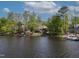 Scenic lakefront property surrounded by mature trees, colorful landscaping, and offering tranquil waterfront views at 955 Sagamore Dr, Louisburg, NC 27549