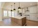 Bright kitchen features a large center island with white countertop and stainless steel appliances at 0006 Tallulah Loop Lane, Cedar Grove, NC 27231