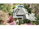 Stunning aerial view of a home featuring a private pool, lush landscaping, and a circular driveway nestled in a wooded setting at 10001 Sandcreek Ct, Chapel Hill, NC 27517