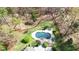 Aerial view of the backyard pool featuring a stone surround, mature trees, and lounge chairs at 10001 Sandcreek Ct, Chapel Hill, NC 27517
