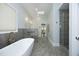 Bright bathroom features a soaking tub, tiled shower, and access to the outdoor patio at 10001 Sandcreek Ct, Chapel Hill, NC 27517