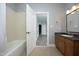 Bathroom with a tub and shower and a door leading to another room with gray flooring at 10001 Sandcreek Ct, Chapel Hill, NC 27517