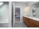 Bathroom with double vanity and a door leading to another room with gray flooring at 10001 Sandcreek Ct, Chapel Hill, NC 27517