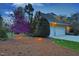 Charming home exterior with manicured landscaping, a two-car garage, a winding driveway, and illuminated by landscape lighting at 10001 Sandcreek Ct, Chapel Hill, NC 27517