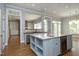 Bright kitchen features a large island with granite countertops, wine fridge and open shelving at 10001 Sandcreek Ct, Chapel Hill, NC 27517