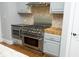 Close up view of stainless steel stove with hood, microwave, butcher block and custom cabinets at 10001 Sandcreek Ct, Chapel Hill, NC 27517