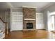 Bright living room featuring a stone fireplace, built-in shelving, hardwood floors, and plenty of natural light at 10001 Sandcreek Ct, Chapel Hill, NC 27517