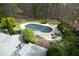 An aerial view of a kidney-shaped pool surrounded by lounge chairs and a lush backyard at 10001 Sandcreek Ct, Chapel Hill, NC 27517
