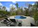 View of the inviting backyard pool with a stone patio, mature trees, and lounge chairs at 10001 Sandcreek Ct, Chapel Hill, NC 27517