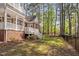 Brick home showcasing a deck with stairs descending to a grassy backyard surrounded by mature trees at 101 Preston Arbor Ln, Cary, NC 27513