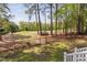A tranquil backyard view shows a lush green lawn and towering trees near the home's back wooden deck at 101 Preston Arbor Ln, Cary, NC 27513