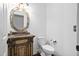 A half bathroom featuring a decorative mirror, vanity, toilet, and hardwood floors at 101 Preston Arbor Ln, Cary, NC 27513