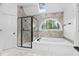 Luxurious bathroom featuring a soaking tub, glass-enclosed shower, and natural light at 101 Preston Arbor Ln, Cary, NC 27513